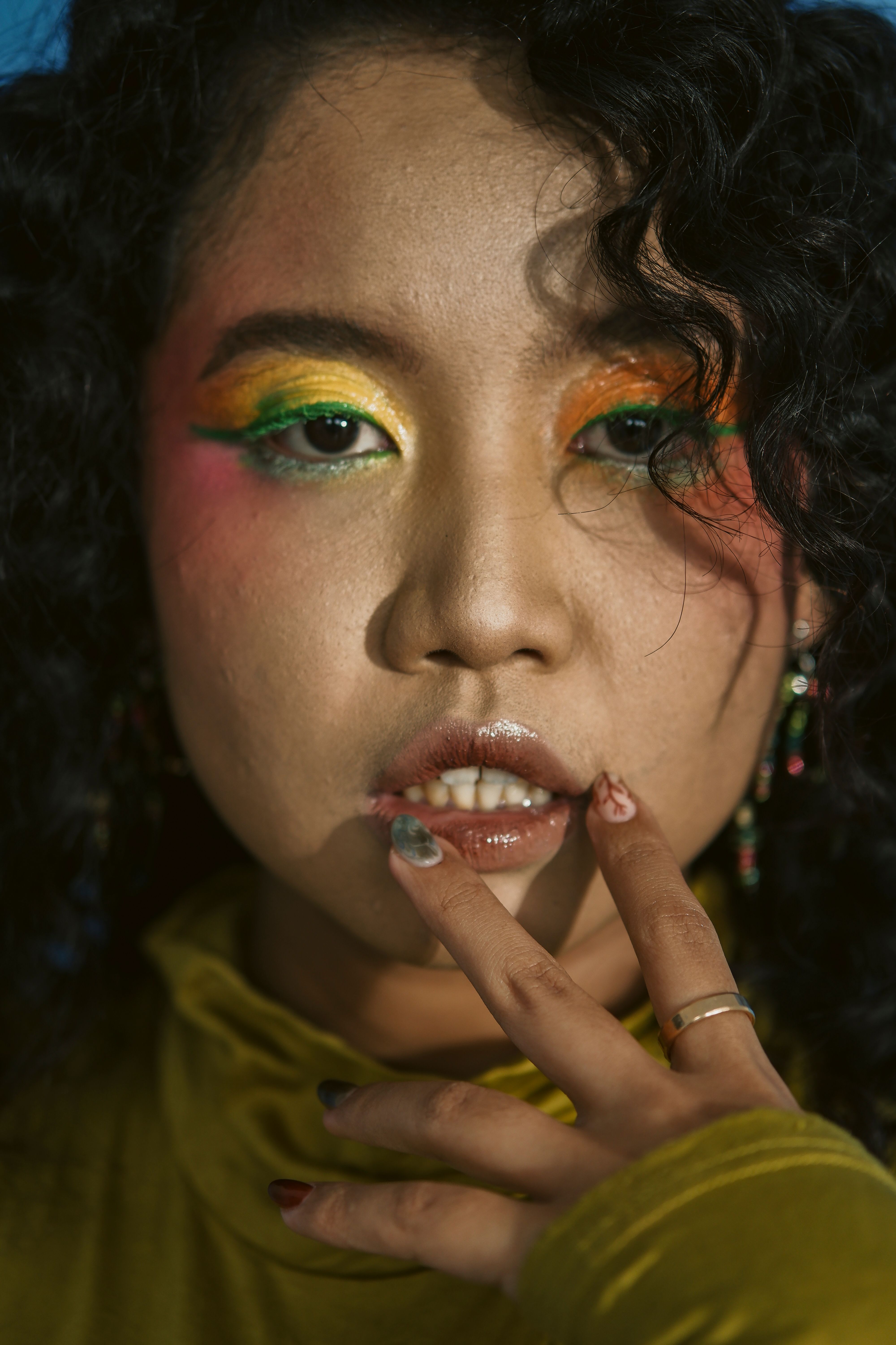 Close portrait showing colorful eye makeup and lip color